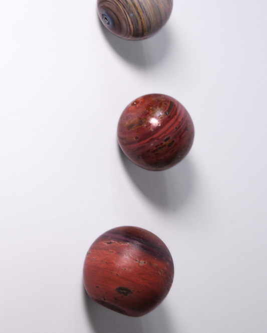 Three circular glass incense holders with a red and brown pattern on a white background