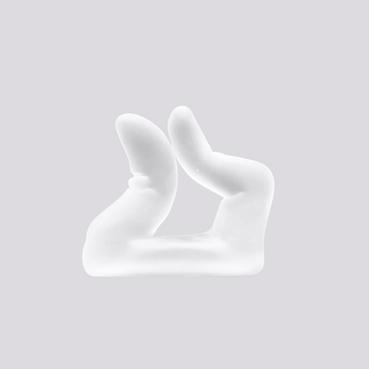 a handmade glass incense holder in the shape of a tantric hand gesture against a green background